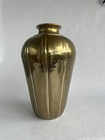 Front view of metal vase showing its fluted design and brass color.