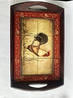 Top-down view of the wooden tray showing the detailed rooster decorative tiles, red border, and overall design.