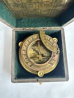 Compass sitting inside open felt-lined wooden box showing instrument placement