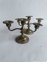 Side view of one of the two vintage sterling silver candelabras, showing 3 candle holders and detailed base with tarnish.
