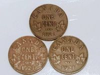 Reverse side of three 1921 Canadian one cent coins showing denomination 'ONE CENT', year '1921', and maple leaf design.