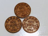Three 1934 Canadian one cent coins showing the reverse with 'CANADA ONE CENT 1934' and maple leaves design.
