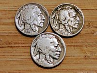 Obverse view showing Indian Head design and date 1936 on three Buffalo Nickels, moderate wear visible