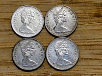 Obverse side of four Canadian 10 cent coins showing the embossed portrait of Queen Elizabeth II.