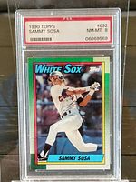 Front of the 1990 Topps Sammy Sosa baseball card showing player batting in White Sox uniform with colorful border and name details.