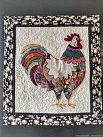 Full view of quilted rooster wall hanging measuring approximately 18x20 inches, showing detailed rooster patchwork and floral border.