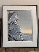 Full view of framed art print showing bird on rock and seascape background.