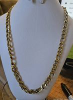 Front view of a gold plated men's chain necklace displayed on a white mannequin bust, showing the link design and length.