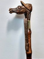 Another angle of the horse head top portion showing details of carving, eye, nostril, and cap tight fitting over the head with a shiny surface.