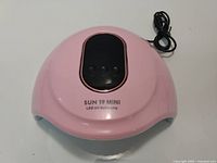 Front view of pink SUN 19 MINI LED UV Nail Lamp with control panel and power cable visible.