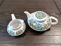 Teapot and cream dish set showing overall design, shape, and patterns.