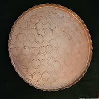 Full top view of copper tray with geometric pattern and scalloped edge, shows natural wear and patina.