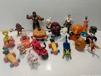 Top view of full lot showing 18 vintage McDonald's cartoon toy figures on a white surface