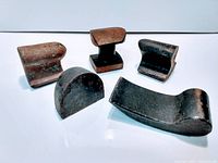 Five vintage metal hand tools shown on white background. Tools are aged, solid, heavy and vary in shape. Image documents condition and size relation of tools.