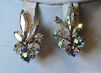 Front view of the pair of gold-tone clip-on earrings with multiple Aurora Borealis rhinestones in various shapes and sizes arranged in a floral cluster