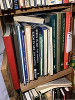 Books on a wooden shelf showing large hardcover art books by Robert Bateman and others.