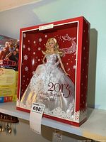 Front view of the 2013 Holiday Barbie doll inside the original box with holiday-themed decorations and label.