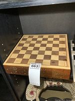 Wooden chess board shown from the top, highlighting the checkered playing surface and wooden construction.