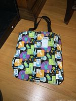 Elvis Presley cloth beach bag with colorful repeating pattern of his face and silhouette