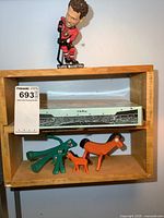 Photo showing the Gumby and Pokey rubber figures along with the boxed SkyLine soccer game and Clute McCarthy bobblehead on a wooden shelf