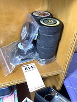 Shelf display with several stacked hockey pucks including some with colorful logos and vintage cartoon hockey player on top puck