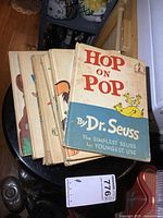 Six vintage Dr. Seuss and related children's books stacked with 'Hop on Pop' on top showing wear on cover.
