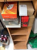 Boxes of Compliments matchbooks on shelf, showing six cases with orange-yellow gradient packaging.