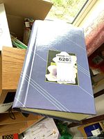 Blue trading card album closed shown on a table near a window.