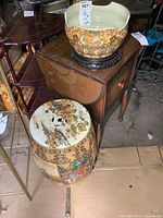Porcelain planter bowl on wooden base and decorative porcelain pedestal beside it.