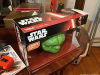 Photo of the Star Wars box containing the Yoda 3D Deco Light showing the packaging and the green Yoda head inside with Star Wars branding.