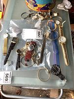 Full assortment of ladies watches laid out including metal, leather, and plastic straps