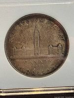Reverse side of 1939 Canadian silver dollar showing Parliament buildings and Peace Tower with inscriptions