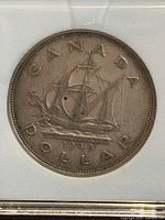 Close-up of the coin reverse showing a detailed sailing ship with inscriptions "CANADA DOLLAR 1949" and "NEWFOUNDLAND."
