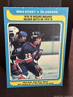 Front of 1979-80 O-Pee-Chee Mike Bossy hockey card showing him skating in uniform, labeled as record breaker for 1978-79 season.