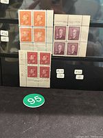 Three blocks of four Canadian King George VI stamps in different denominations and colors, displayed in a protective sleeve.