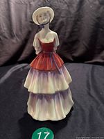 Front view of Royal Doulton Eliza figurine on black fabric background, showing detailed dress and hat