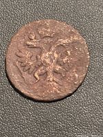 Obverse side showing the double-headed eagle emblem of the Russian Empire on the copper coin, details worn but discernible.