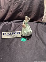 Photo of the Coalport figurine 'Pamela' front view with Coalport sign beside it for brand identification and size reference.
