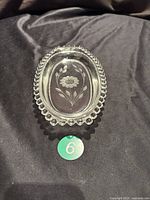 Top view of oval glass dish showing central etched cornflower floral motif and candlewick edge.