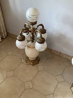 Full view of the large vintage Italian style ceramic and brass lamp with multiple white globes on brass arms and a hexagonal brass base.