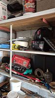 Shelves displaying assorted tools, chargers, and hardware including red socket wrench set, battery chargers, glass jar, and Mastercraft tool.