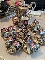 Full set arranged on table showing coffee pot, sugar bowl, cream jug and multiple cups and saucers