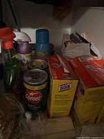 Various household cleaning supplies including Comet, SOS soap pads, Easy-Off oven cleaner, and Spill Spot antibacterial spray bottle.