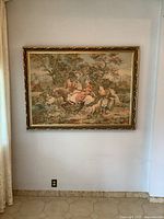 Full view of the framed large tapestry showing the wall mounted piece with a pastoral landscape scene of figures and animals.
