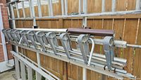 Long view of Tapco bender frame with all clamps, metal bars and rake leaning against fence