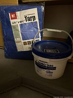 Blue tarp package and Leslie's Jumbo Tabs bucket shown together.