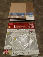 Photo showing two 5-piece packs of 8x10 inch wood art panels stacked, plus three adhesive flex stencils by Martha Stewart in original packaging with nature designs visible.