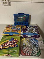 Photo of all five games including Connect 4 Shots, Tribond Jr., two Mathematics Lab games, and Coloring Treasures