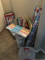 Corner view showing rolls of wrapping paper, gift bags with Santa Claus image, tissue paper pad, and plastic storage boxes.