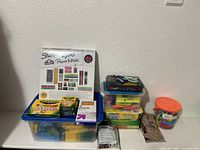 Complete view of school supplies in plastic storage bins including branded boxes and miscellaneous items